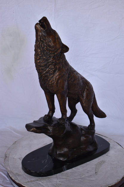 Howling Wolf at Edge of a Cliff Bronze Statue - Size: 9"L x 20"W x 26"H.