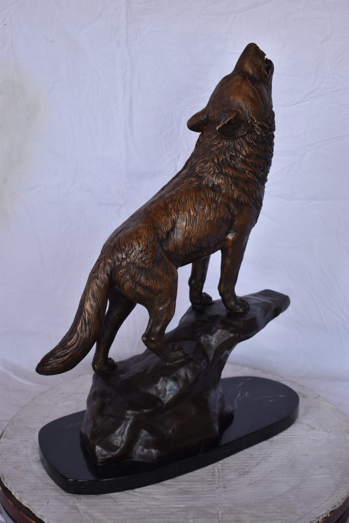 Howling Wolf at Edge of a Cliff Bronze Statue - Size: 9"L x 20"W x 26"H.