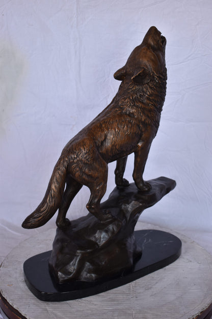 Howling Wolf at Edge of a Cliff Bronze Statue - Size: 9"L x 20"W x 26"H.