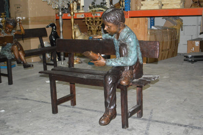 boy Sitting on a Bench reading book bronze Statue -  Size: 43"L x 20"W x 36"H.