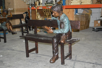 boy Sitting on a Bench reading book bronze Statue -  Size: 43"L x 20"W x 36"H.