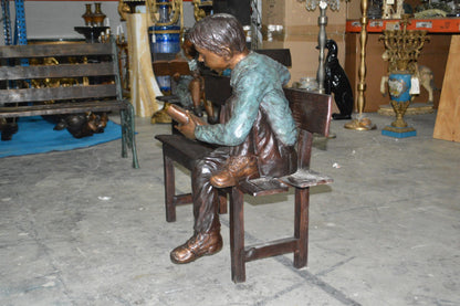 boy Sitting on a Bench reading book bronze Statue -  Size: 43"L x 20"W x 36"H.
