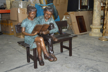 Boy and a Girl on Bench reading book bronze Statue -  Size: 43"L x 20"W x 36"H.
