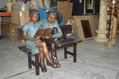Boy and a Girl on Bench reading book bronze Statue -  Size: 43"L x 20"W x 36"H.