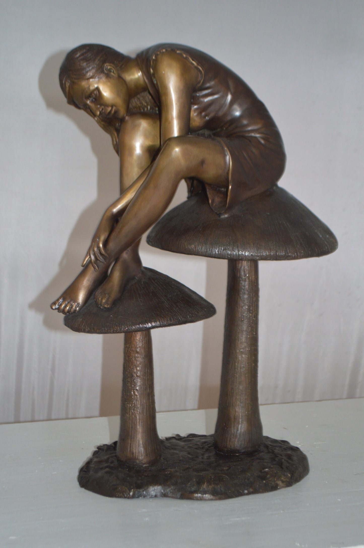 Girl sitting on Mushrooms Bronze Statue -  Size: 13"L x 11"W x 18"H.