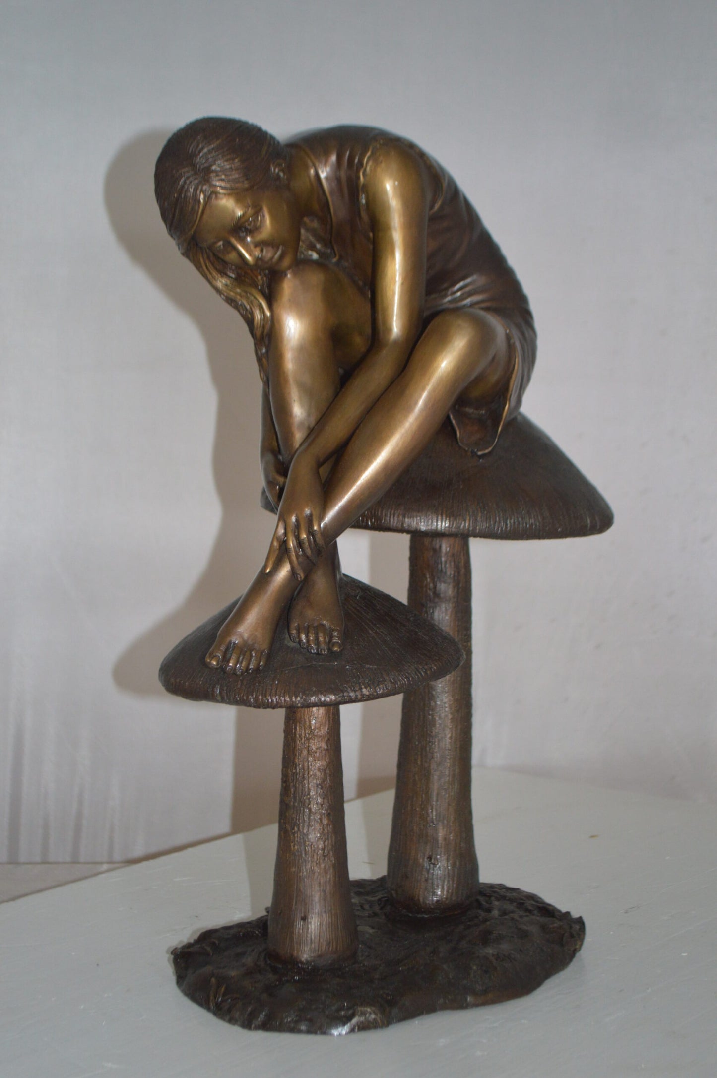 Girl sitting on Mushrooms Bronze Statue -  Size: 13"L x 11"W x 18"H.