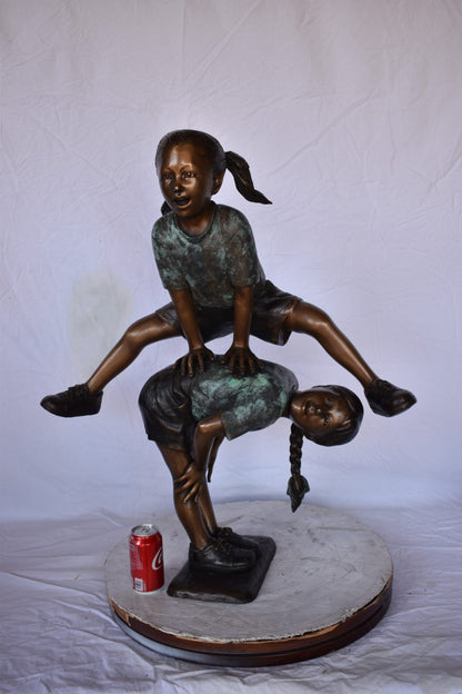 Two Girls Playing Leapfrog Jumping Bronze Statue - Size: 30"L x 14"W x 34"H.