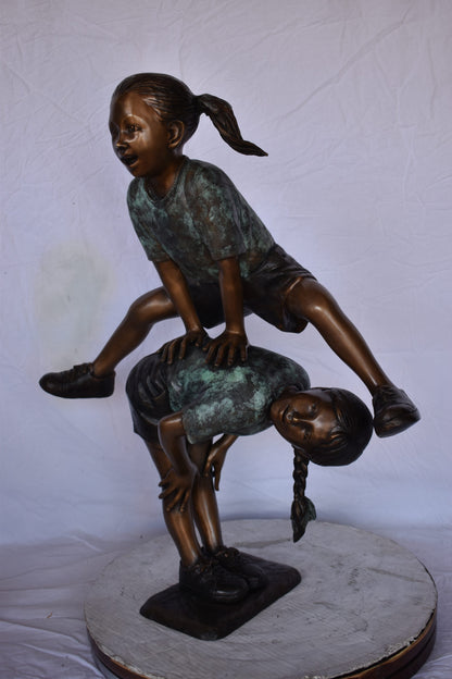 Two Girls Playing Leapfrog Jumping Bronze Statue - Size: 30"L x 14"W x 34"H.