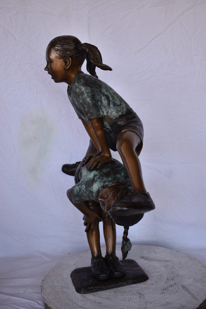 Two Girls Playing Leapfrog Jumping Bronze Statue - Size: 30"L x 14"W x 34"H.