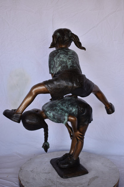 Two Girls Playing Leapfrog Jumping Bronze Statue - Size: 30"L x 14"W x 34"H.