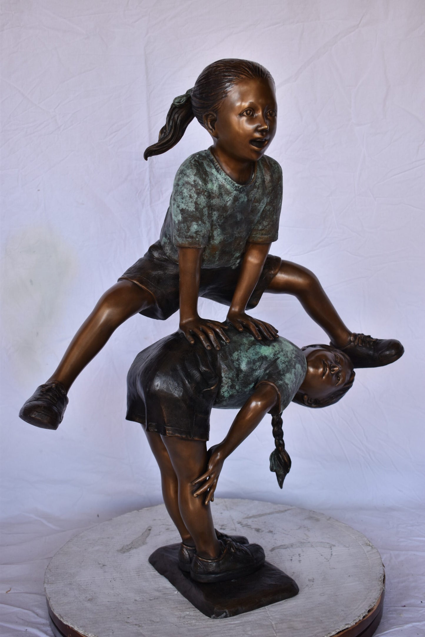 Two Girls Playing Leapfrog Jumping Bronze Statue - Size: 30"L x 14"W x 34"H.