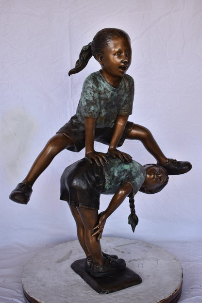 Two Girls Playing Leapfrog Jumping Bronze Statue - Size: 30"L x 14"W x 34"H.