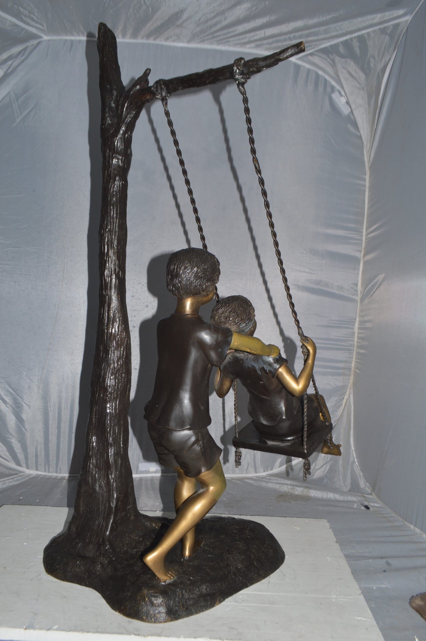 Kids Playing on a Swing bronze Statue -  Size: 22"L x 25"W x 43"H.