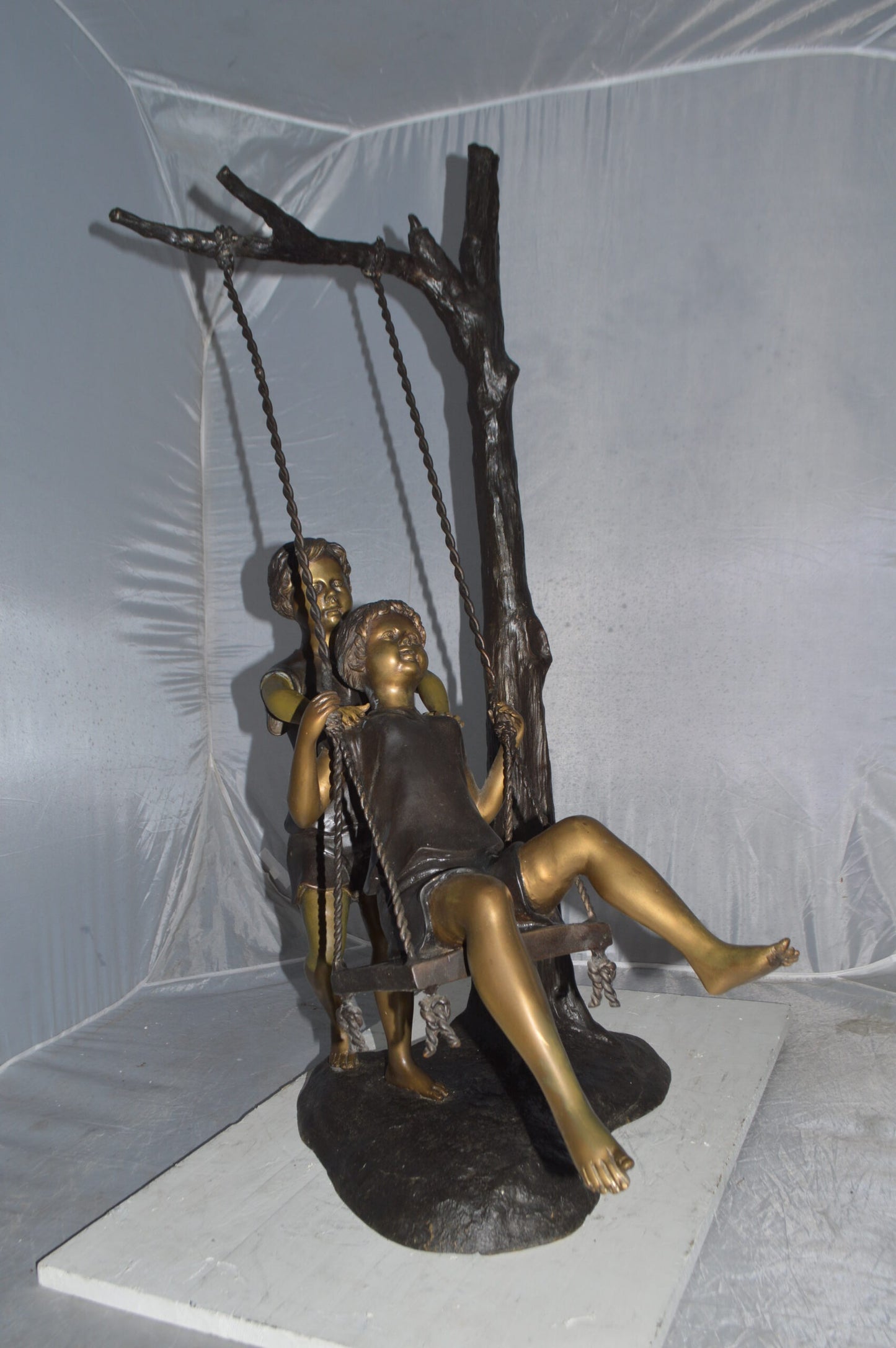 Kids Playing on a Swing bronze Statue -  Size: 22"L x 25"W x 43"H.