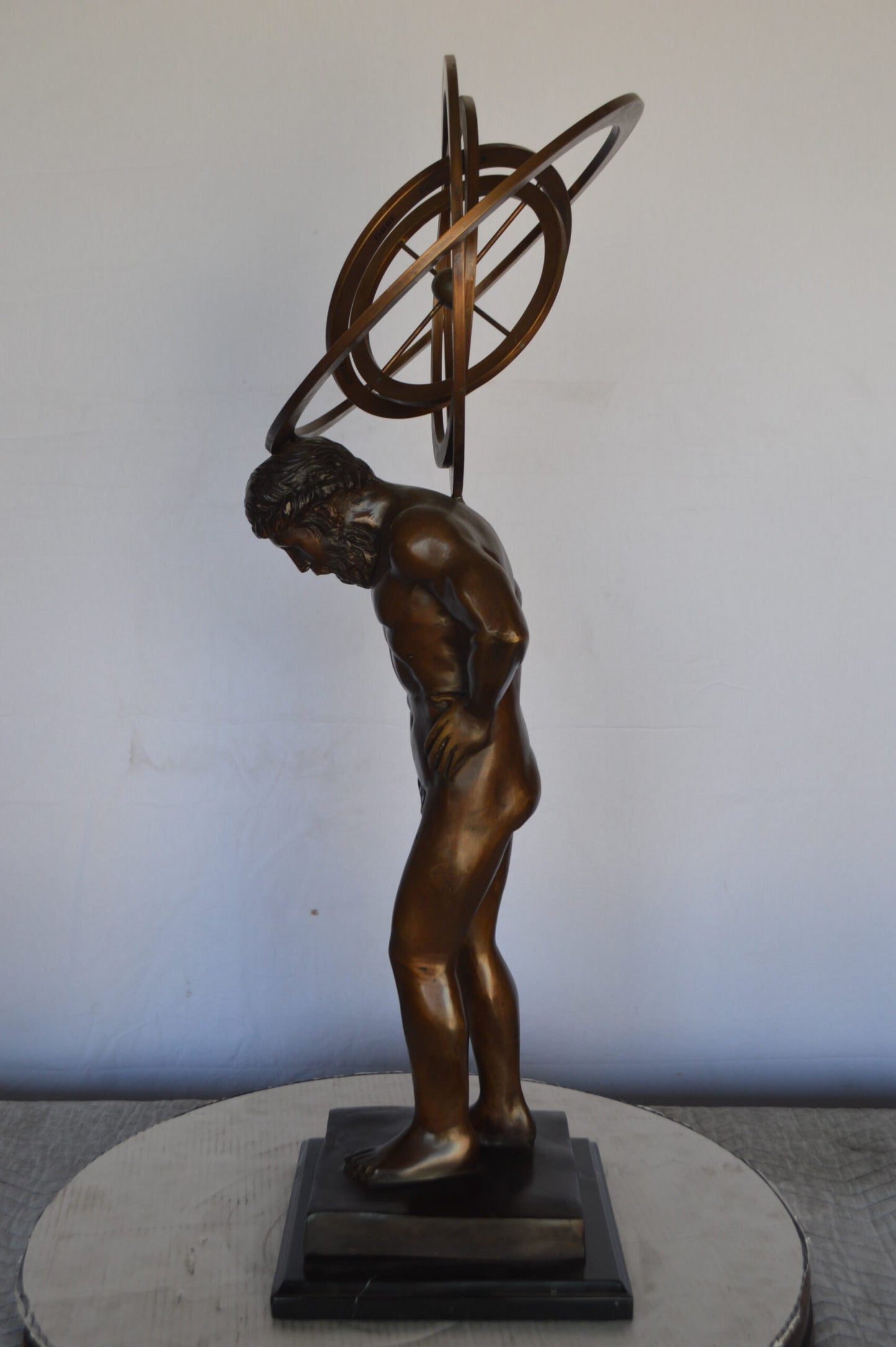 Man with Sundial on his Back Bronze Statue -  Size: 14"L x 12"W x 35"H.