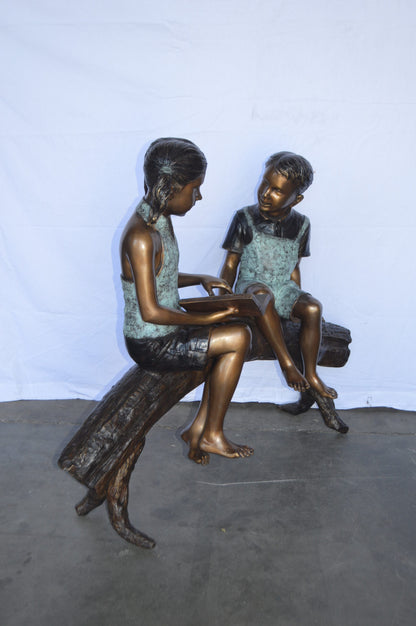 Two Kids on a tree log reading Bronze Statue Large -  Size: 44"L x 17"W x 42"H.