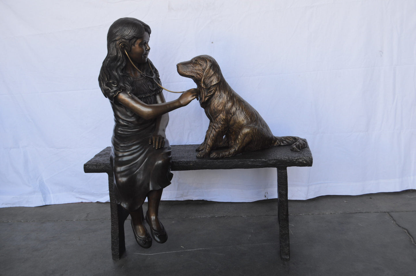 Girl plays Doctor on a Bench W Dog Bronze Statue -  Size: 38"L x 18"W x 39"H.