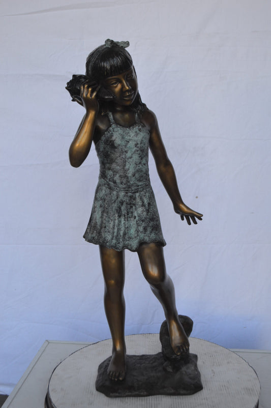 Standing Girl Listening to a Shell Bronze Statue -  Size: 16"L x 12"W x 37"H.