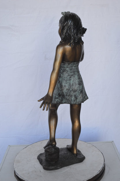 Standing Girl Listening to a Shell Bronze Statue -  Size: 16"L x 12"W x 37"H.