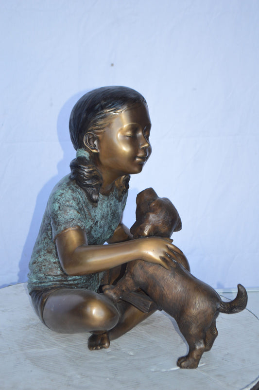Girl Petting her Dog While Reading Bronze Statue -  Size: 13"L x 18"W x 18"H.