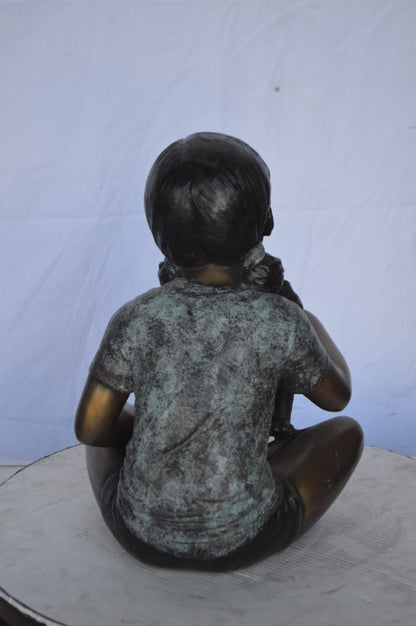 Girl Petting her Dog While Reading Bronze Statue -  Size: 13"L x 18"W x 18"H.