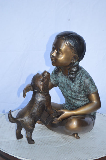 Girl Petting her Dog While Reading Bronze Statue -  Size: 13"L x 18"W x 18"H.