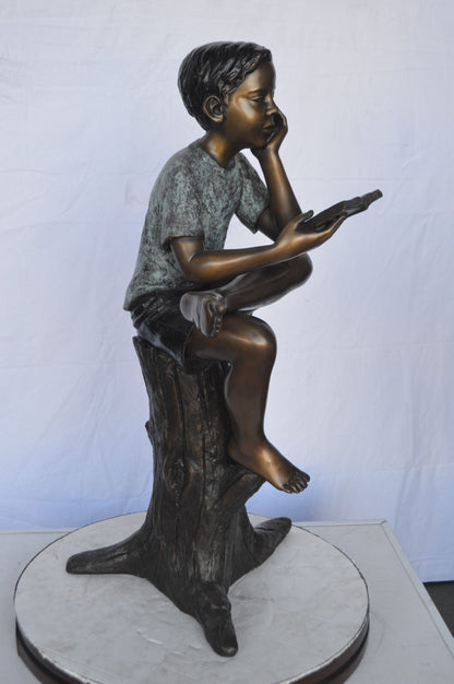 Boy Sitting on a Stump Reading a Book -  Size: 18"L x 20"W x 35"H.