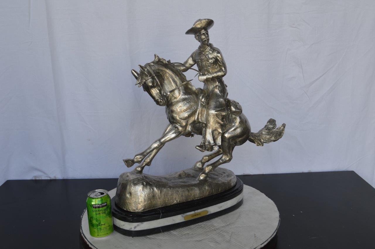Remington Cowboy silver finished Bronze Statue -  Size: 24"L x 9"W x 24"H.