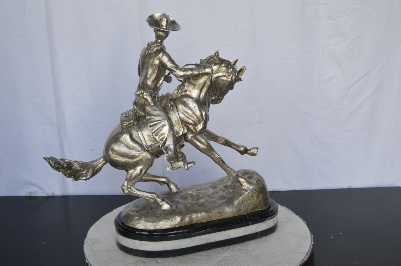 Remington Cowboy silver finished Bronze Statue -  Size: 24"L x 9"W x 24"H.