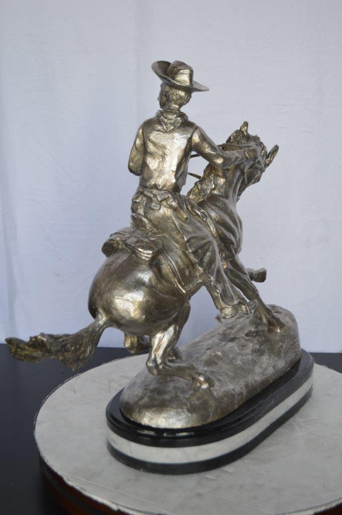 Remington Cowboy silver finished Bronze Statue -  Size: 24"L x 9"W x 24"H.