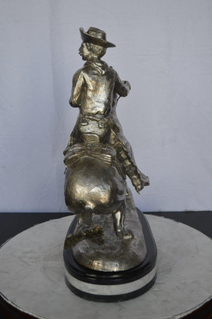 Remington Cowboy silver finished Bronze Statue -  Size: 24"L x 9"W x 24"H.