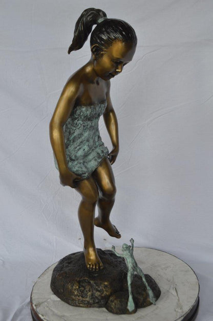 Girl looking at a frog bronze statue -  Size: 16"L x 13"W x 36"H.