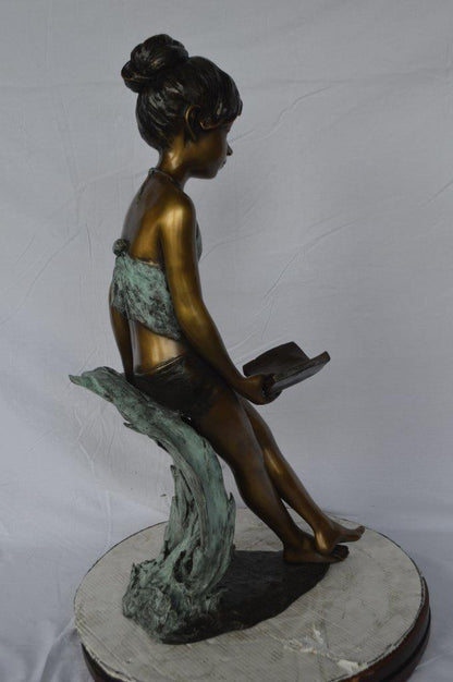 Girl sitting and reading a book bronze statue -  Size: 19"L x 15"W x 36"H.