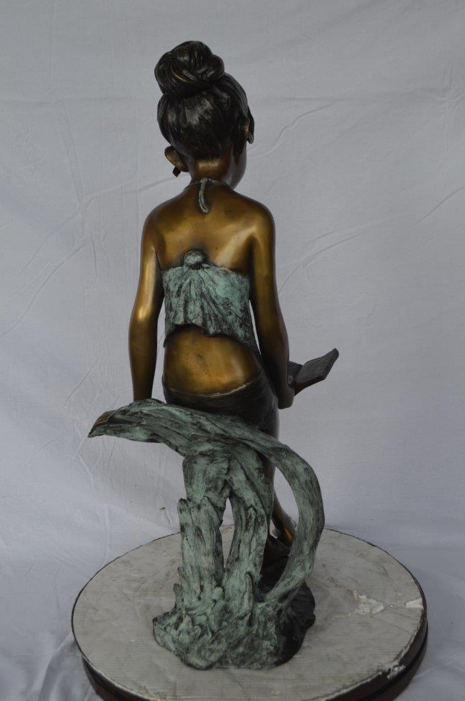 Girl sitting and reading a book bronze statue -  Size: 19"L x 15"W x 36"H.