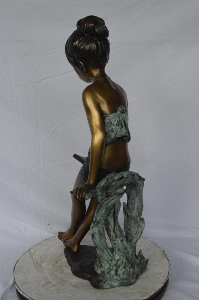 Girl sitting and reading a book bronze statue -  Size: 19"L x 15"W x 36"H.
