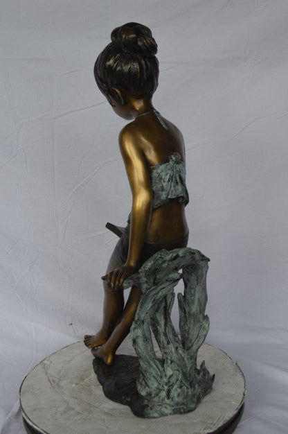 Girl sitting and reading a book bronze statue -  Size: 19"L x 15"W x 36"H.