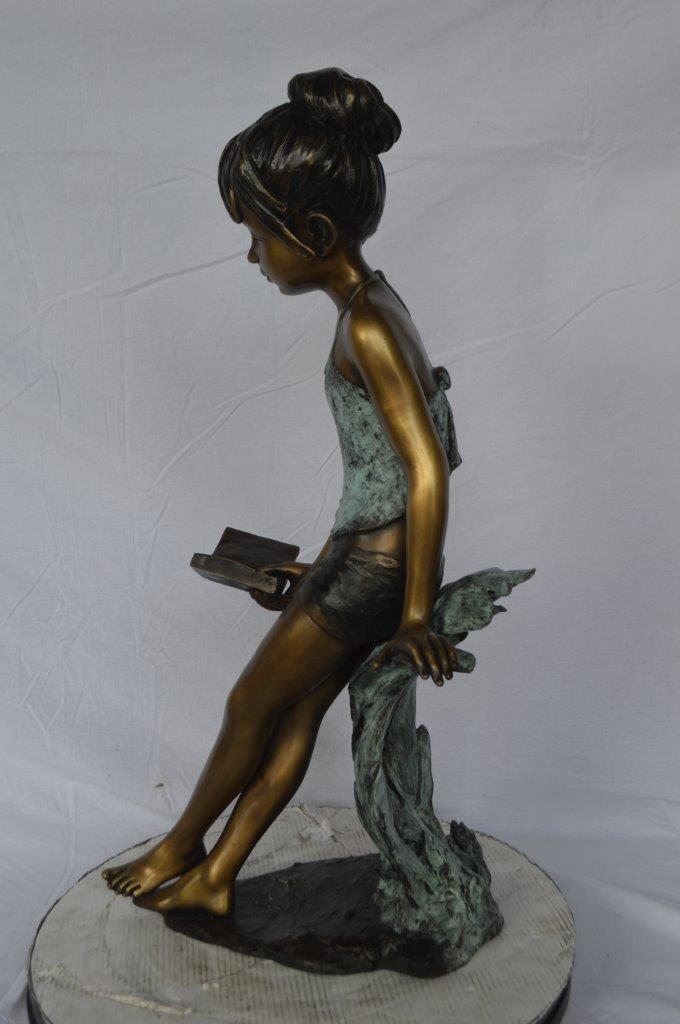 Girl sitting and reading a book bronze statue -  Size: 19"L x 15"W x 36"H.
