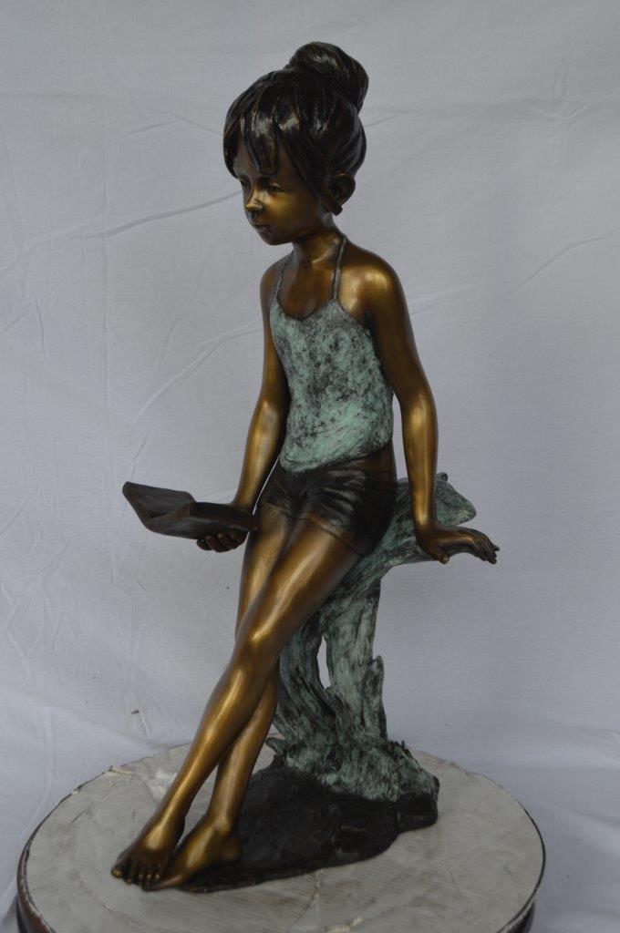 Girl sitting and reading a book bronze statue -  Size: 19"L x 15"W x 36"H.