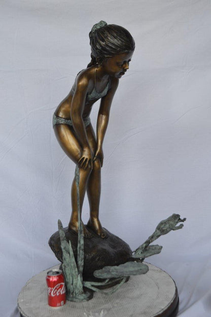 Girl looking at frog jumping bronze fountain -  Size: 21"L x 15"W x 38"H.