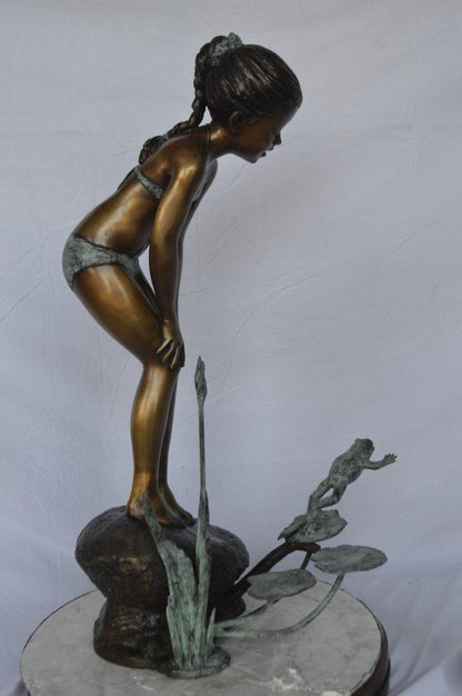 Girl looking at frog jumping bronze fountain -  Size: 21"L x 15"W x 38"H.