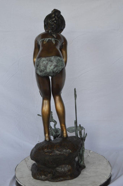 Girl looking at frog jumping bronze fountain -  Size: 21"L x 15"W x 38"H.