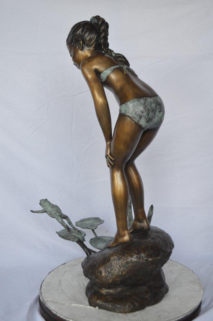 Girl looking at frog jumping bronze fountain -  Size: 21"L x 15"W x 38"H.