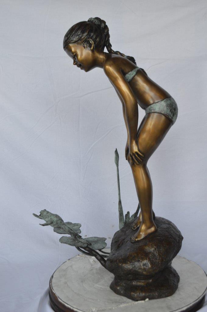 Girl looking at frog jumping bronze fountain -  Size: 21"L x 15"W x 38"H.