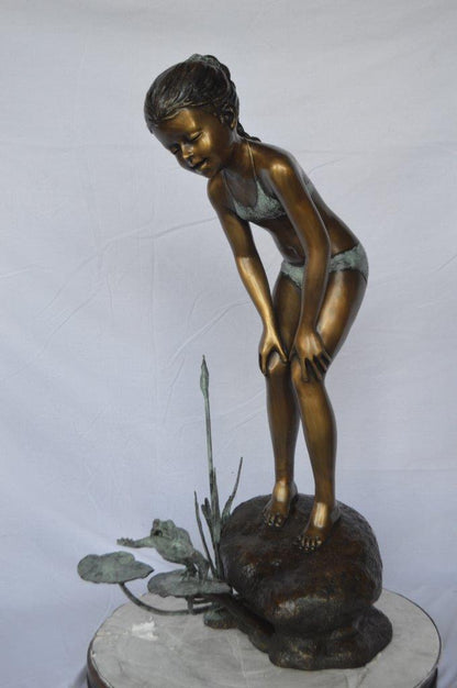 Girl looking at frog jumping bronze fountain -  Size: 21"L x 15"W x 38"H.