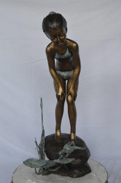 Girl looking at frog jumping bronze fountain -  Size: 21"L x 15"W x 38"H.