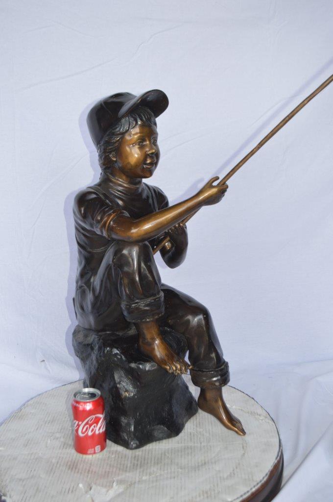 Young Boy sitting on a rock fishing bronze statue -  Size: 31"L x 9"W x 33"H.