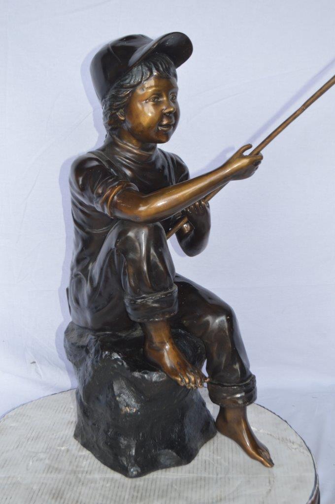 Young Boy sitting on a rock fishing bronze statue -  Size: 31"L x 9"W x 33"H.