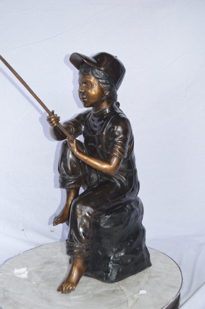 Young Boy sitting on a rock fishing bronze statue -  Size: 31"L x 9"W x 33"H.