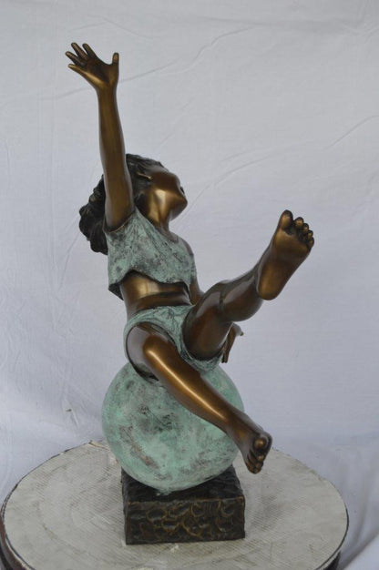 Girl having fun on apple bronze statue -  Size: 22"L x 9"W x 31"H.