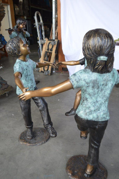 Three children happily holding hands bronze statue -  Size: 31"L x 19"W x 41"H.
